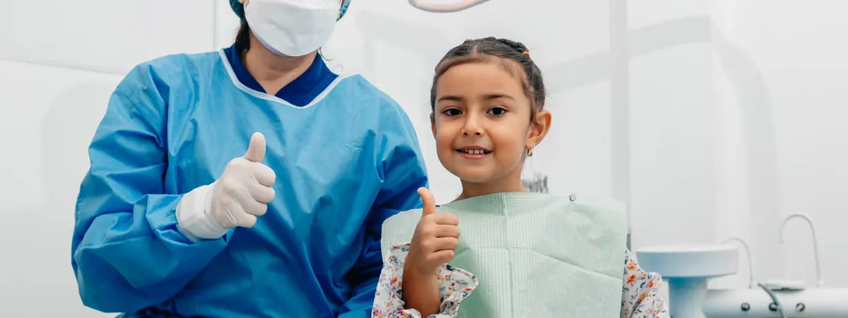 Friendly pediatric dentist and smiling child during gentle anxiety-free dental check-up at Deekshu Dental Sarjapura Bangalore